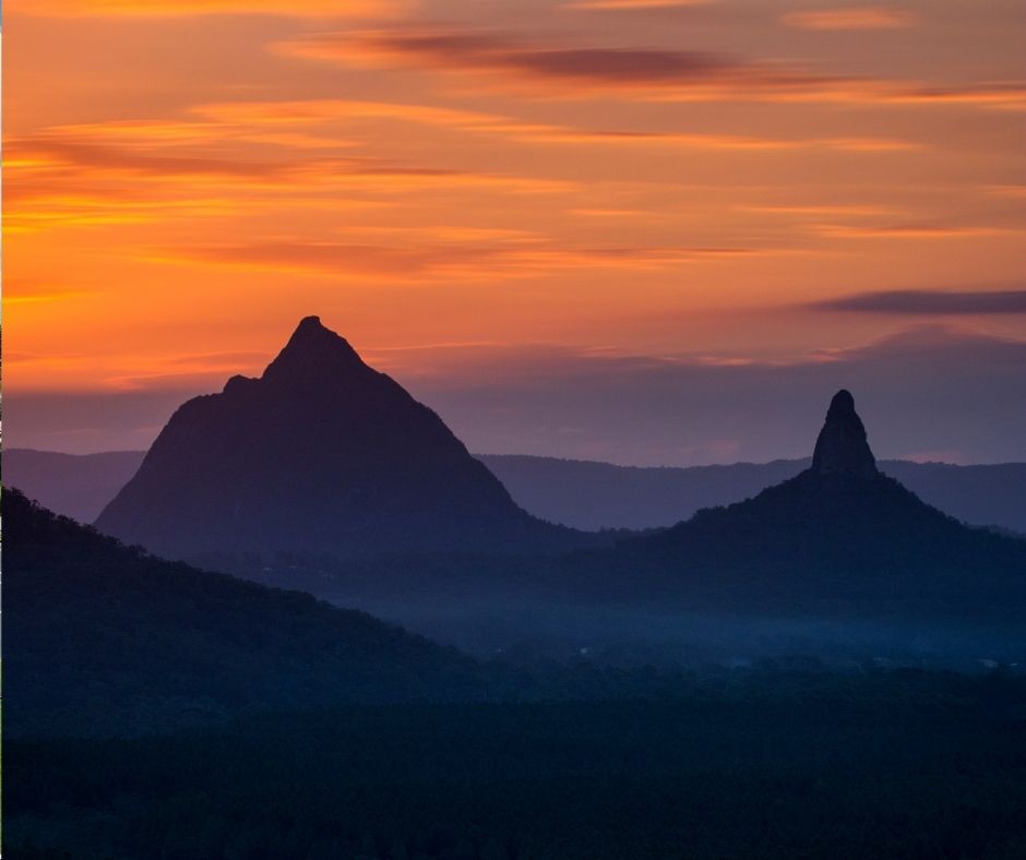 A breathtaking sunset over the Glass House Mountains, showcasing the natural beauty and stunning landscapes of the Sunshine Coast Hinterland.